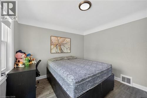 Room featuring light gray walls, white trim, and wood-finish flooring - 43 West 1St Street, Hamilton, ON 