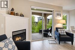 Living room with gas fireplace and access to spacious covered deck. (digitally altered photos – leaves added) - 