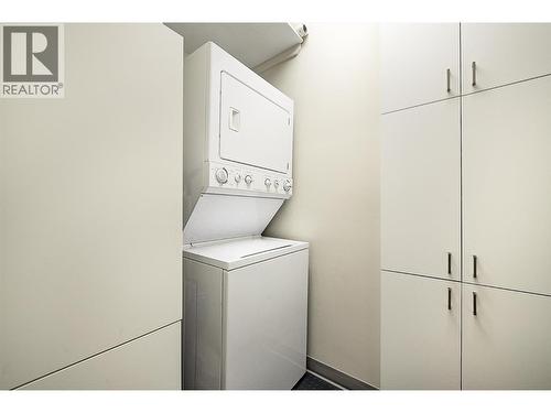 Laundry room with cabinets for extra storage - 1960 Enterprise Way Unit# 412, Kelowna, BC - Indoor Photo Showing Laundry Room