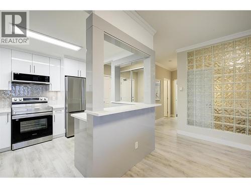 Beautifully updated kitchen with stainless steel appliances and quartz counters - 1960 Enterprise Way Unit# 412, Kelowna, BC - Indoor Photo Showing Kitchen With Stainless Steel Kitchen