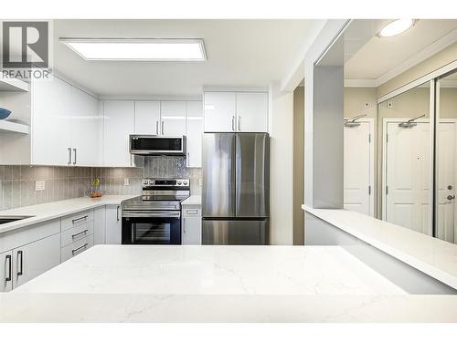 Beautifully updated kitchen with stainless steel appliances and quartz counters - 1960 Enterprise Way Unit# 412, Kelowna, BC - Indoor Photo Showing Kitchen With Stainless Steel Kitchen