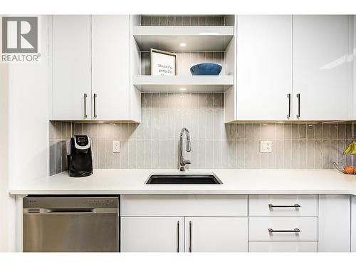 Beautifully updated kitchen with stainless steel appliances and quartz counters - 1960 Enterprise Way Unit# 412, Kelowna, BC - Indoor Photo Showing Kitchen
