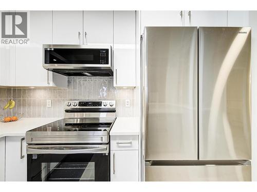 Beautifully updated kitchen with stainless steel appliances and quartz counters - 1960 Enterprise Way Unit# 412, Kelowna, BC - Indoor Photo Showing Kitchen With Stainless Steel Kitchen With Upgraded Kitchen