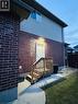 Rear exterior with brick and siding facade, featuring a wooden staircase leading to a white entry door - 1377 Coronation Drive, London, ON  - Outdoor With Exterior 