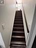 Staircase with dark-stained wood treads and a matching handrail, framed by light-colored walls - 1377 Coronation Drive, London, ON  - Indoor Photo Showing Other Room 