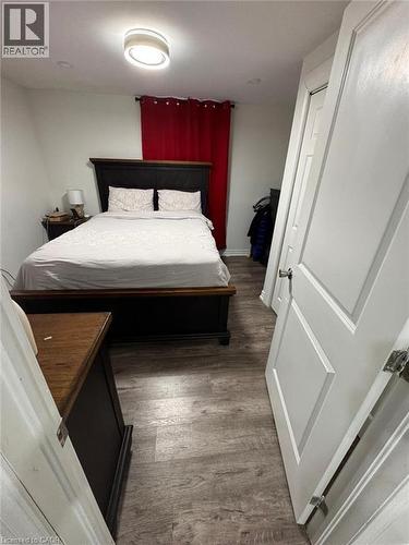 Neutral wall paint and wood-finish flooring with a modern flush-mount ceiling light - 1377 Coronation Drive, London, ON - Indoor Photo Showing Bedroom