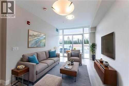 Living room featuring floor to ceiling windows and light wood finished floors - 120 Springvalley Crescent Unit# 104, Hamilton, ON 