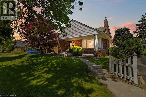Brick exterior with white siding accents and a covered front porch featuring white pillars - 134 Queensway Drive, Brantford, ON 