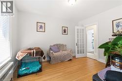 Room featuring wood flooring, white trim, and light wall paint - 