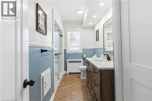 Bathroom featuring a wood-finish herringbone floor and a large vanity with a light-toned countertop - 134 Queensway Drive, Brantford, ON 