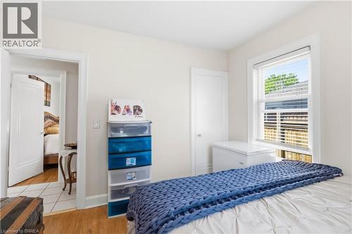 Room featuring wood-finish flooring, white painted walls, and a single window with blinds - 134 Queensway Drive, Brantford, ON 