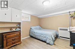 Room featuring light wood-finish flooring, textured wall covering, and a white ceiling with a flush-mount light fixture - 