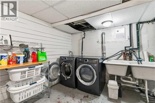 Dedicated laundry area featuring a washer and dryer, a double utility sink, and a window for natural light - 134 Queensway Drive, Brantford, ON 