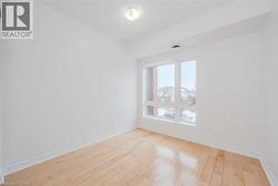 Bright room featuring a large window, light wood-finish flooring, white walls, white trim, and a ceiling-mounted light fixture - 