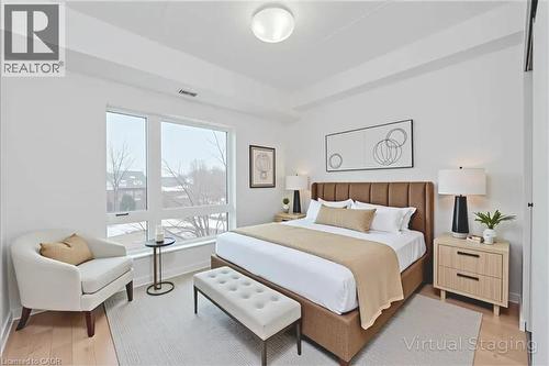 Bright room with large windows, wood-finish flooring, and a modern overhead light fixture - 41 Goodwin Drive Unit# 202, Guelph, ON 