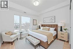 Bright room with large windows, wood-finish flooring, and a modern overhead light fixture - 