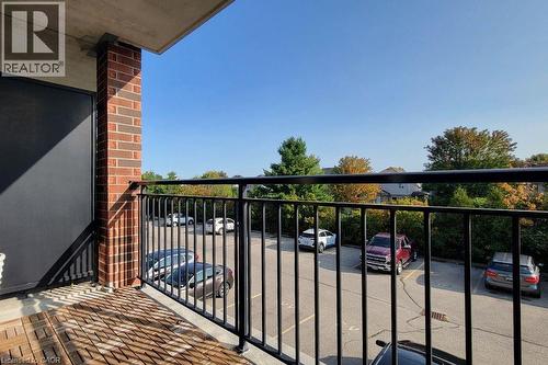 Private balcony featuring wood-finish flooring and a black metal railing - 41 Goodwin Drive Unit# 202, Guelph, ON 