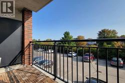 Private balcony featuring wood-finish flooring and a black metal railing - 