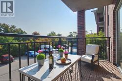 Private balcony featuring wood-finish tile flooring and a black metal railing - 