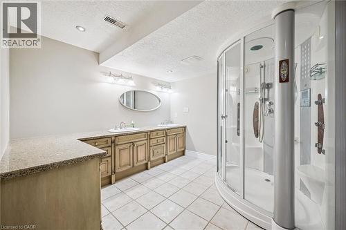 Spacious bathroom featuring a curved glass shower enclosure, dual vanity - 44 Mcnichol Drive, Cambridge, ON - Indoor Photo Showing Bathroom