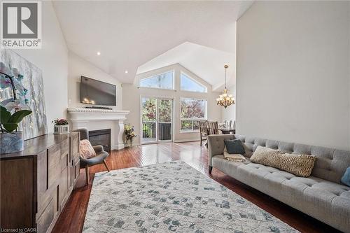 Open-concept living space featuring hard wood flooring, a fireplace and a vaulted ceiling with recessed lighting - 44 Mcnichol Drive, Cambridge, ON - Indoor Photo Showing Living Room With Fireplace