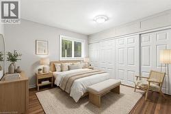 *VIRTUALLY STAGED* Bedroom featuring wood-finish flooring, a contemporary window with blinds, and white sliding closet doors - 