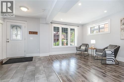 Entryway featuring a white door with decorative glass inlay, recessed lighting, wood-finish flooring, and a large window providing ample ambient light - 40 Woodland Avenue, Kitchener, ON 