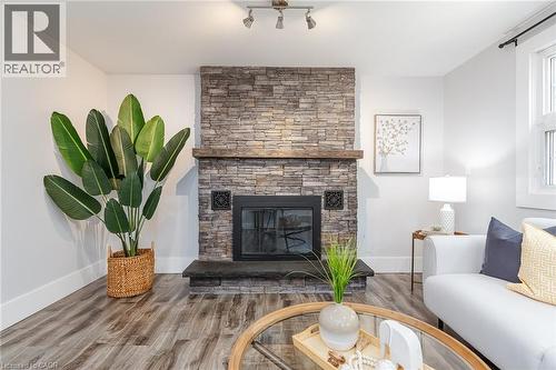 Stone-clad fireplace featuring a wood mantel and hearth - 40 Woodland Avenue, Kitchener, ON 
