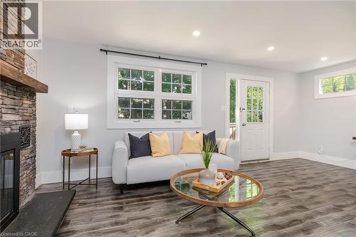 Living area featuring a floor-to-ceiling stone-faced fireplace with a wood mantel - 40 Woodland Avenue, Kitchener, ON 