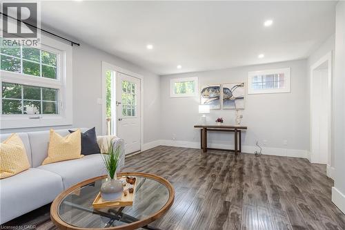 Bright living area featuring wood-finish flooring, recessed lighting, and white baseboards - 40 Woodland Avenue, Kitchener, ON 