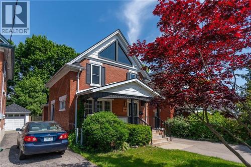 Room featuring wood-finish flooring, a three-panel interior door with brushed nickel hardware, and neutral wall tones - 40 Woodland Avenue, Kitchener, ON 