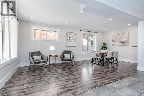 Light-filled interior featuring wood-finish flooring, white trim, and a contemporary door with dark hardware - 40 Woodland Avenue, Kitchener, ON 