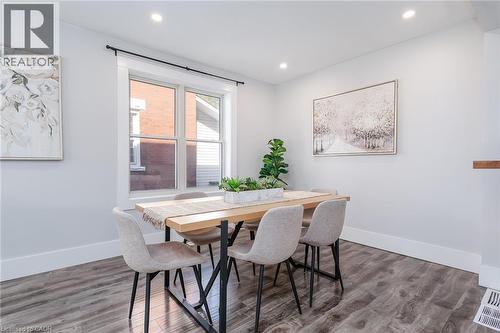 Spacious room featuring wood-finish flooring, recessed lighting, and a dark-toned built-in wardrobe with mirrored panels - 40 Woodland Avenue, Kitchener, ON 