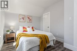 Light-filled interior featuring wood-finish flooring, white trim, and a contemporary door with dark hardware - 