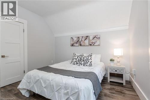 Room featuring wood-finish flooring, a three-panel interior door with brushed nickel hardware, and neutral wall tones - 40 Woodland Avenue, Kitchener, ON 