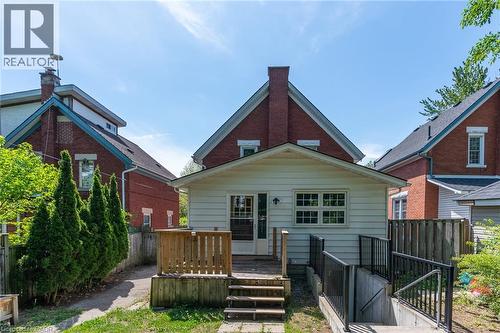 Rear exterior featuring a white siding extension with a wood deck and stairs - 40 Woodland Avenue, Kitchener, ON 
