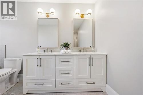Dual vanity with white shaker cabinetry, brushed nickel hardware, and an integrated countertop - 72 Elmbank Trail, Kitchener, ON 