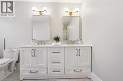 Dual vanity with white shaker cabinetry, brushed nickel hardware, and an integrated countertop - 