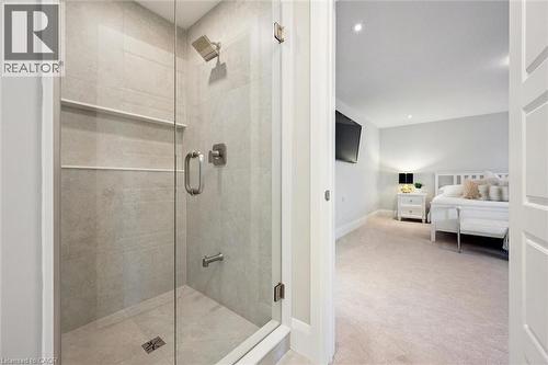 Glass-enclosed shower with full-height tile surround, integrated shelving, and brushed nickel fixtures - 72 Elmbank Trail, Kitchener, ON 
