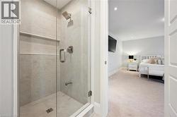 Glass-enclosed shower with full-height tile surround, integrated shelving, and brushed nickel fixtures - 