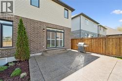 Rear exterior with a concrete patio, brick and siding facade, and a wood fence - 
