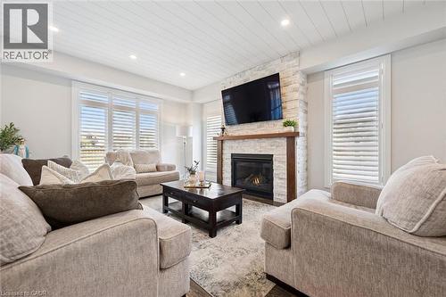 Living area with a stone-clad fireplace featuring a wood mantel - 72 Elmbank Trail, Kitchener, ON 