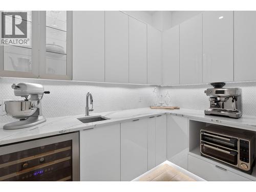 Butlers pantry with sink and beverage fridge. Under cabinet lighting - 5835 Vicary Road, Peachland, BC 