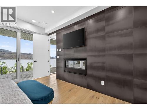 Large bedroom in legal suite with large windows open directly onto a private deck measuring approximately 10.5 ft. x 70 ft. (roughly 735 sq. ft.), complete with its own natural gas BBQ hookup. - 5835 Vicary Road, Peachland, BC 