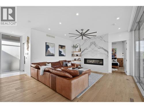 Anchoring the main living area is a spectacular oversized linear fireplace finished with massive book-matched slab tile, creating a striking architectural centrepiece. - 5835 Vicary Road, Peachland, BC 