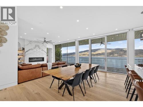 The open-concept living room and kitchen are framed by floor-to-ceiling commercial-style glass designed to capture the expansive lake and mountain views from nearly every angle. - 5835 Vicary Road, Peachland, BC 