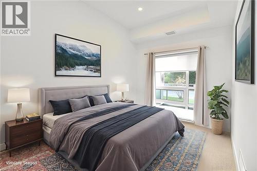 Spacious room featuring a vaulted ceiling, recessed lighting, and a large window with direct exterior access - 4040 Upper Middle Road Unit# 105, Burlington, ON 