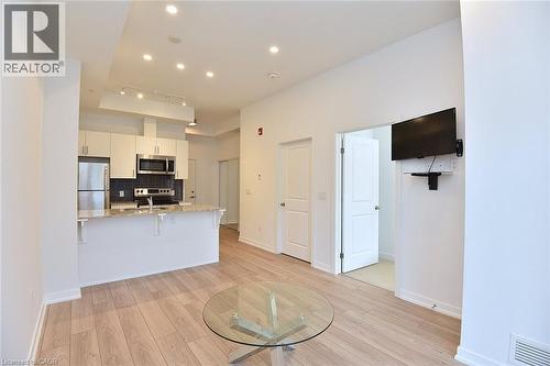 Open-concept living space featuring wood-finish flooring, recessed lighting, and a white color palette - 4040 Upper Middle Road Unit# 105, Burlington, ON 