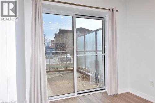 Sliding glass patio door with an exterior privacy screen and wood-finish flooring - 4040 Upper Middle Road Unit# 105, Burlington, ON 