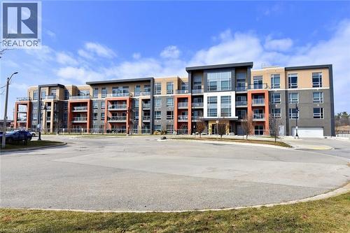Contemporary multi-story building featuring varied facade materials including brick and paneling - 4040 Upper Middle Road Unit# 105, Burlington, ON 